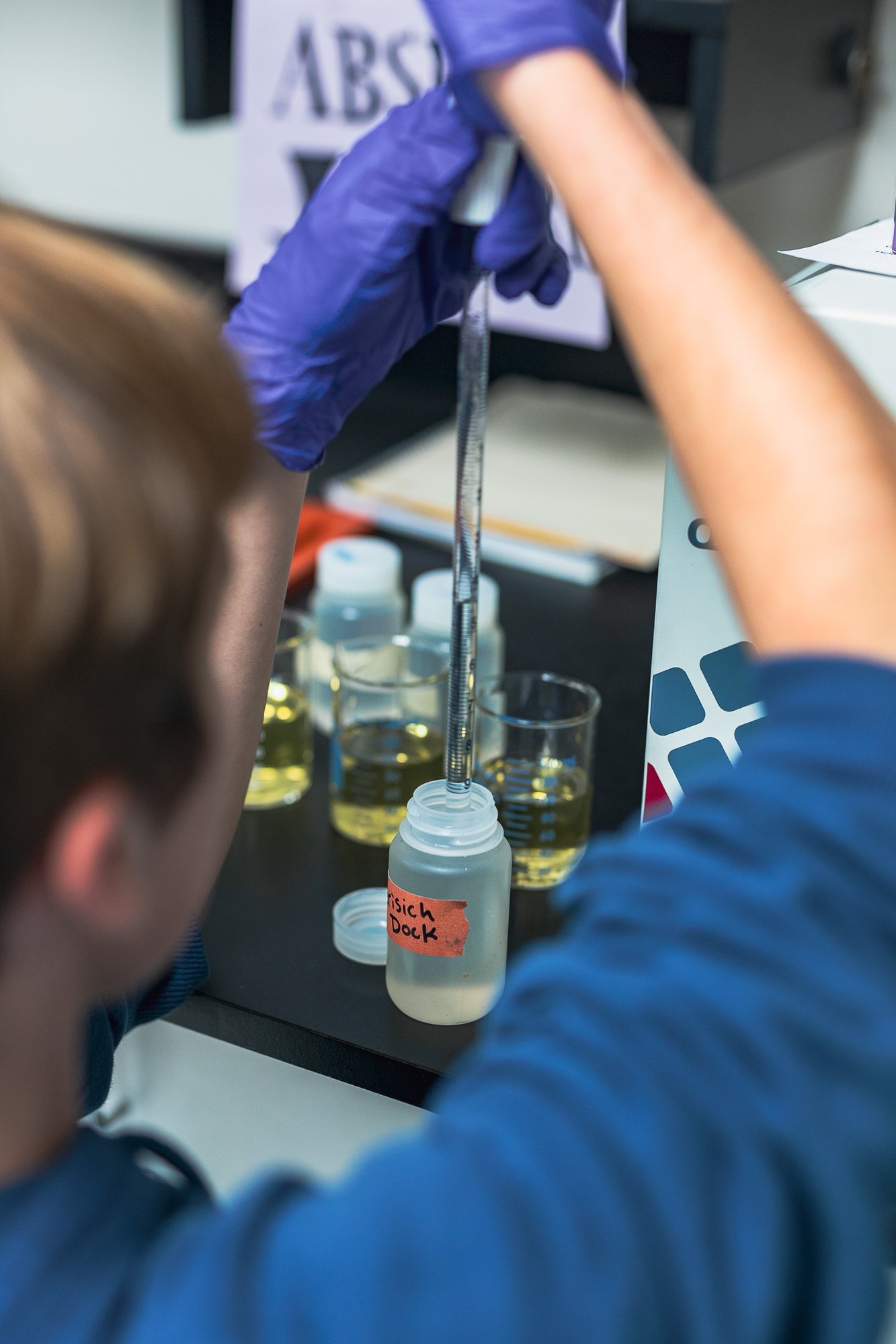  A male volunteer in the chemistry lab testing water samples at the Science and Math Institute School in Tacoma