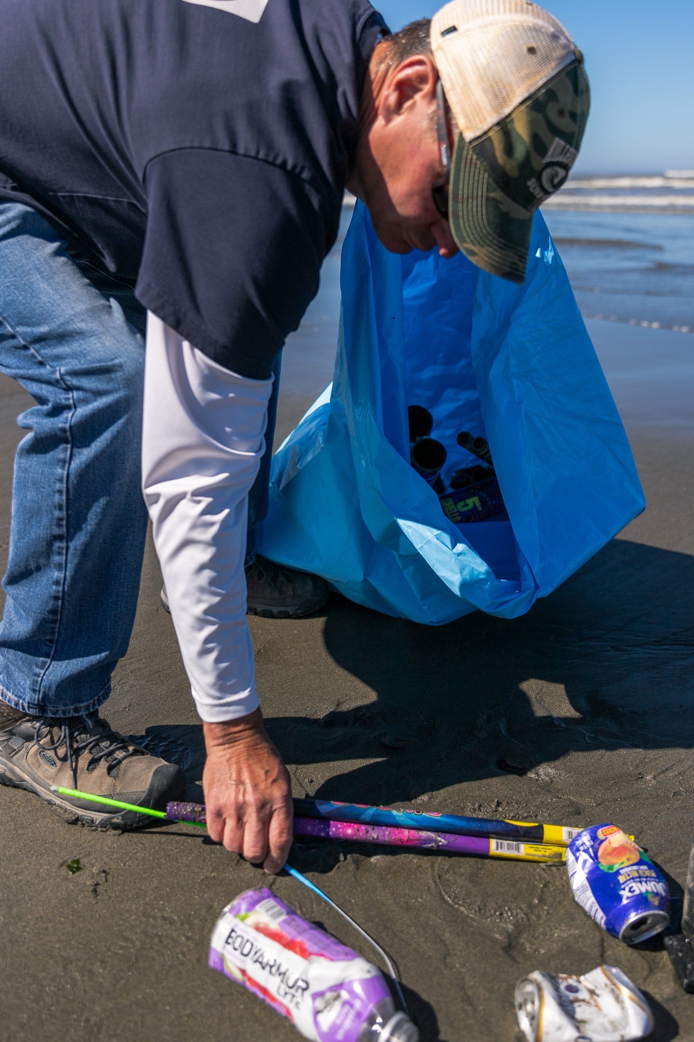 Volunteer picking up trash by water-3